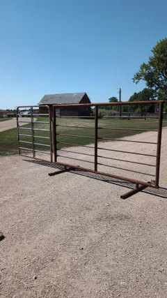Side view of the free-standing panel with the gate swung fully open, showing the skid base and rail spacing